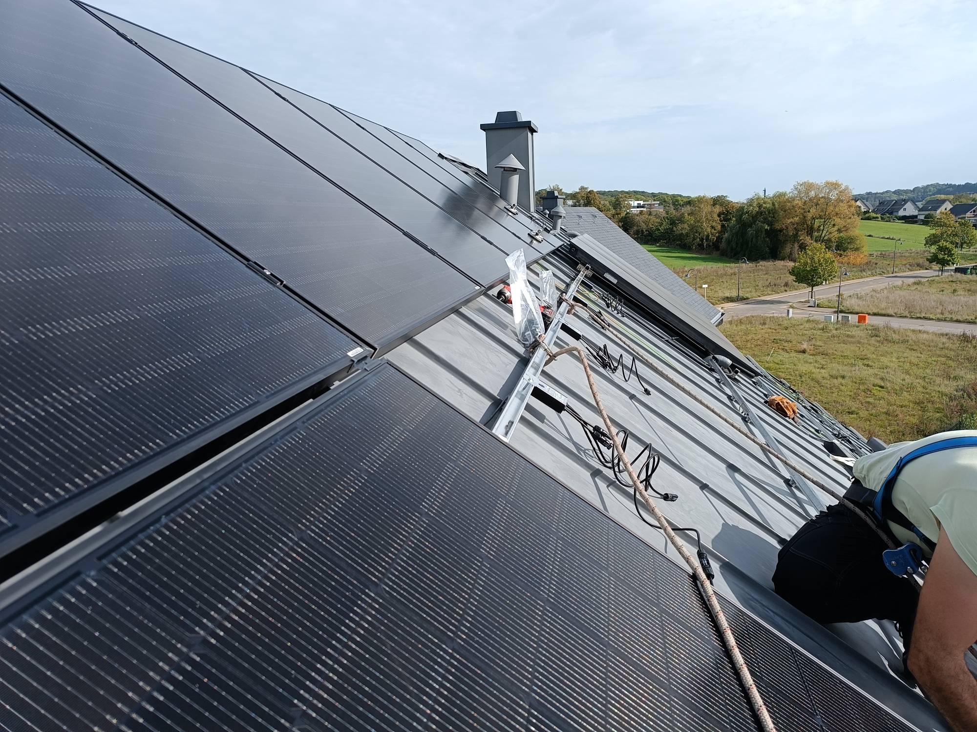 Technicien Céleste Énergie installant des panneaux photovoltaïques sur une toiture